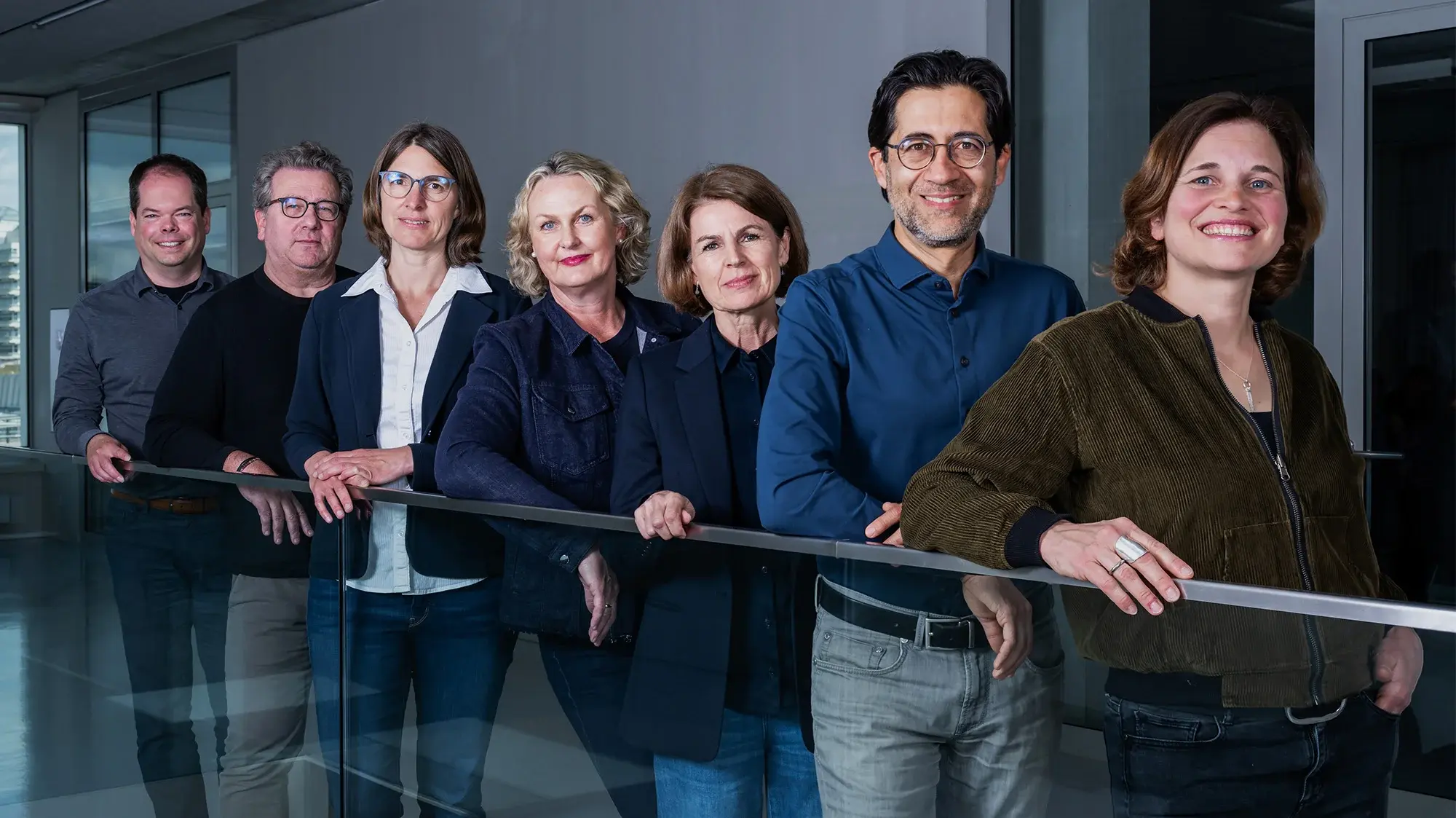 Teamfoto der Professorinnen des Studiengangs Crossmedia-Redaktion/Public Relations. Von hinten nach vorne: Prof. Dr. Alexander Mäder, Prof. Dr. Klaus Kamps, Prof. Dr. Judith Pies, Prof. Dr. Katrin Hassenstein, Prof. Christine Ritz, Prof. Dr. Swaran Sandhu, Prof. Dr. Katarina Bader, .