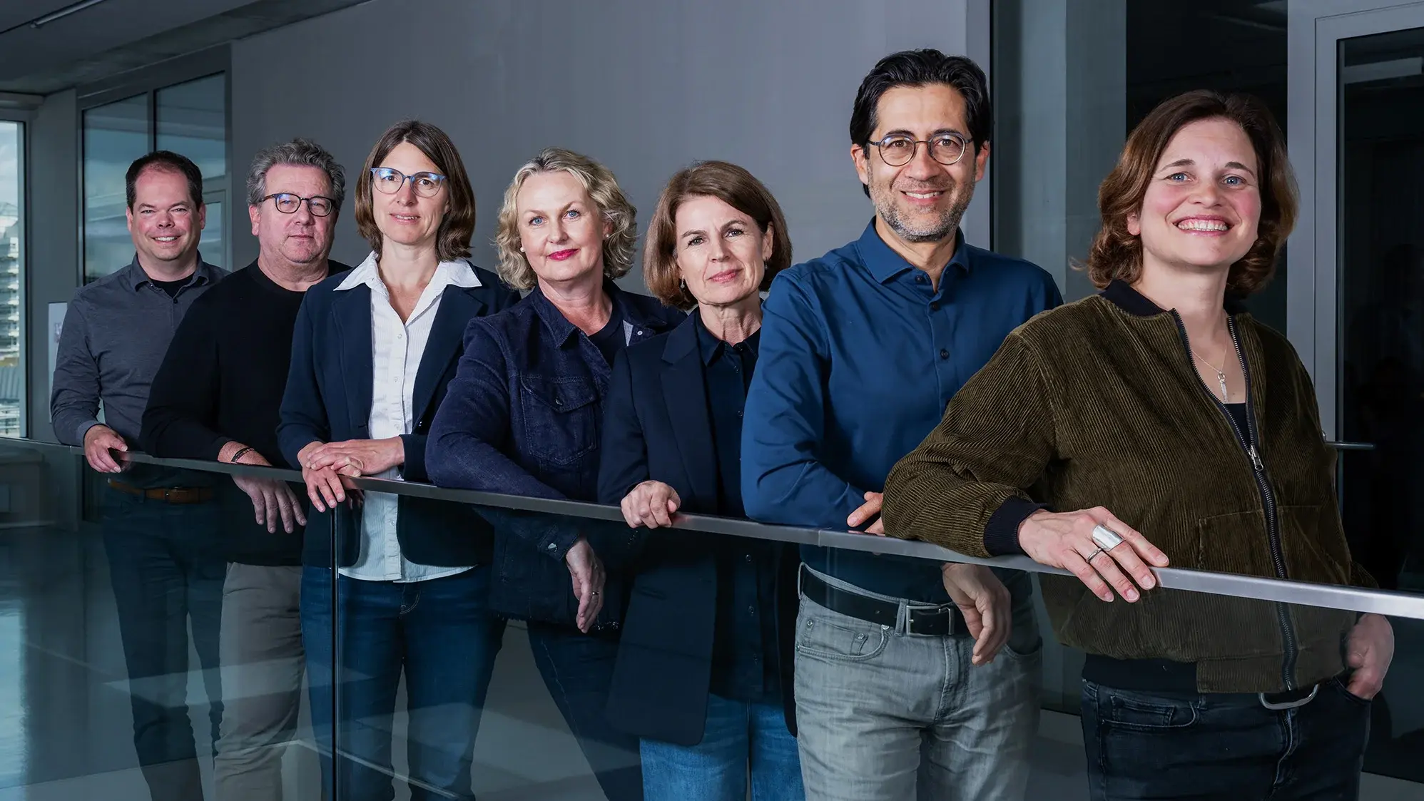 Teamfoto der Professorinnen des Studiengangs Crossmedia-Redaktion/Public Relations. Von hinten nach vorne: Prof. Dr. Alexander Mäder, Prof. Dr. Klaus Kamps, Prof. Dr. Judith Pies, Prof. Dr. Katrin Hassenstein, Prof. Christine Ritz, Prof. Dr. Swaran Sandhu, Prof. Dr. Katarina Bader, .